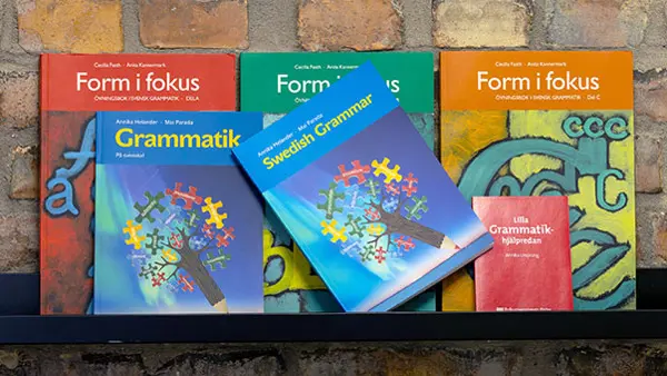 En rad böcker om grammatik som står på en hylla.