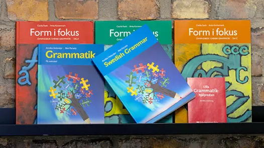 En rad böcker om grammatik som står på en hylla.