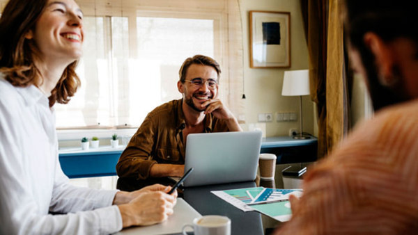Happy friends working together on table at home