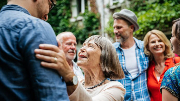 Glada människor från olika generationer möts i en trädgård - på språkkurs!