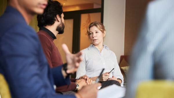 En grupp människor som sitter runt varandra.