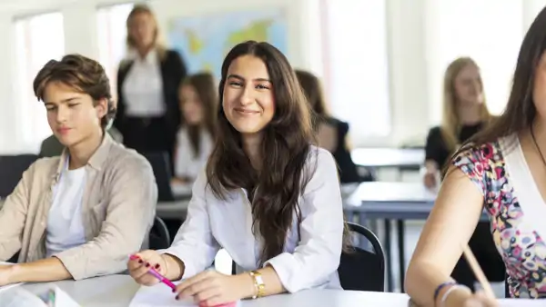 Elever som samarbetar och studerar med sina laptops i klassrummet