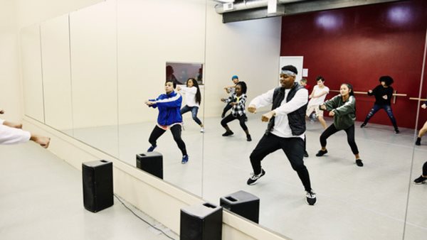 Personer som dansar i spegelsal - Gå en danskurs på Folkuniversitet i Falkenberg