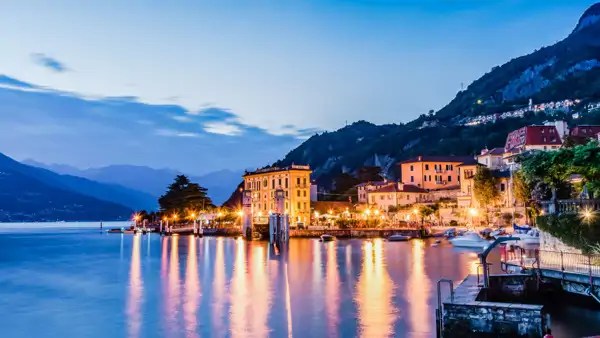 Stad vid Comosjön på kvällen. Läs italienska i Como.