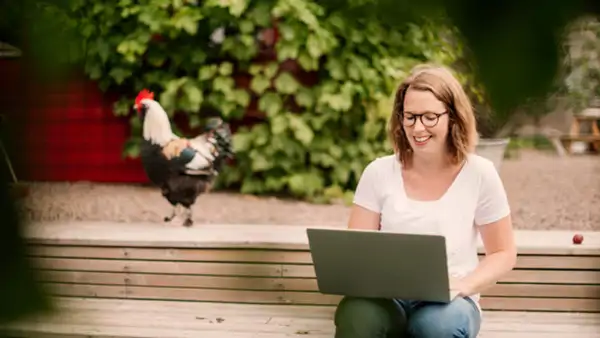 A participant in a course at Folkuniversitetet working on a laptop outside