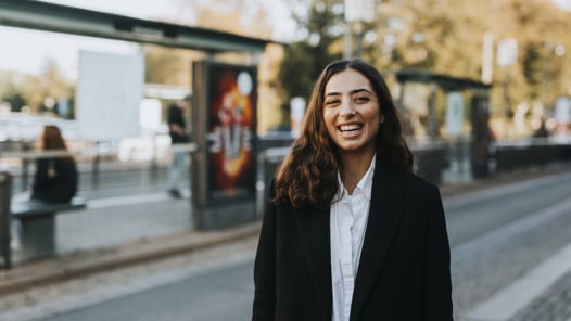 En kvinna som står vid sidan av en gata.