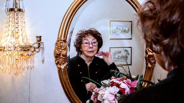 äldre kvinna speglar sig