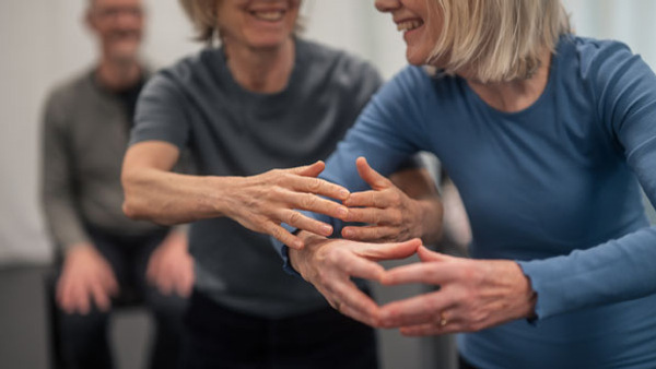 Två äldre personer som dansar och håller i hand. 