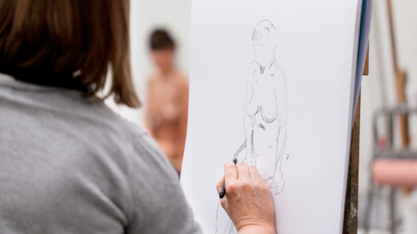 Kursdeltagare övar krokiteckning med levande modelll på konstkurs hos Folkuniversitetet