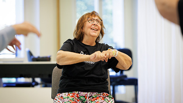 Äldre kvinna som sitter och dansar på Balettakademien Stockholm