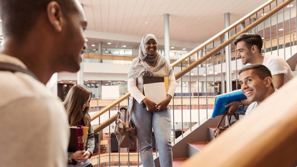 Deltagare samtalar och skrattar i en trappa i modern kontorsbyggnad