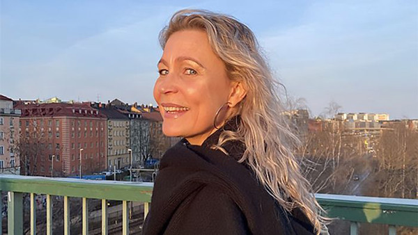 Åsa Sjöwall går över en bro i skymningssolen.