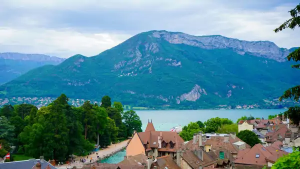 En vacker utsikt över Annecy med Alperna i bakgrunden. Läs franska 50+ i Frankrike.