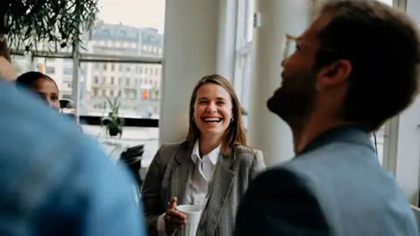 Grupp av personer som dricker kaffe och skrattar