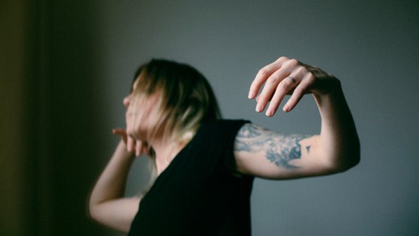 Kvinna med tatueringar dansar. 