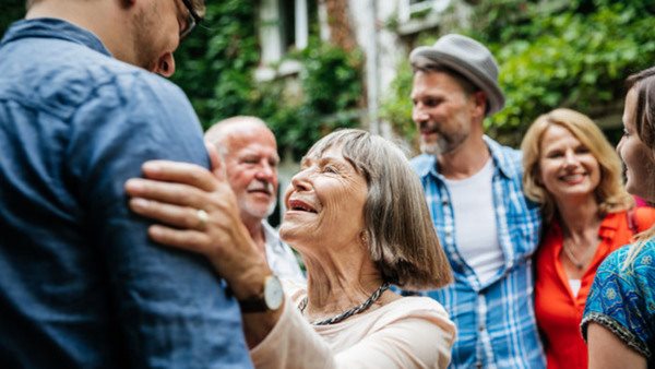 Glada människor från olika generationer möts i en trädgård - på språkkurs!