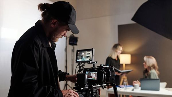 Deltagare filmar med professionell kamera under filmkurs i studio på Folkuniversitetet