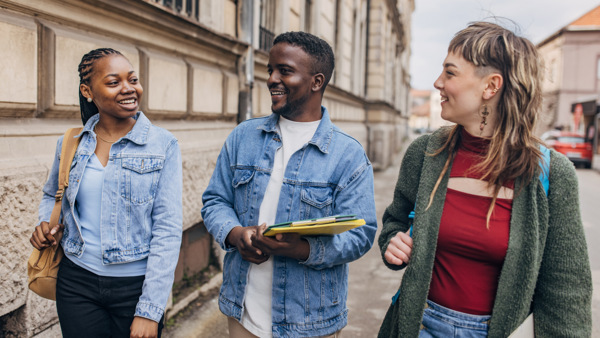 En grupp unga människor som går längs en gata.