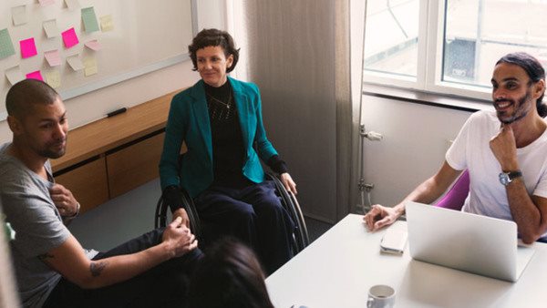 Tre deltagare runt ett bort på kurs inom handel och försäljning