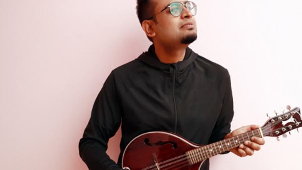 Man i mörk tröja som övar mandolin på musikkurs hos Folkuniversitetet