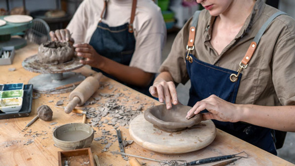 Två kvinnor arbetar med keramik i en keramikverkstad.