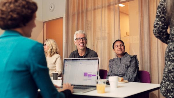 Deltagare runt ett bord som går kurs inom företagsekonomi