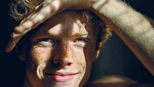 En närbild av en person med fräknar i ansiktet.