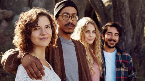 Portrait of a diverse group of smiling friends standing together while out for a nature walk