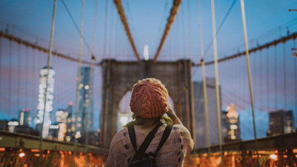 Kvinna som tar en bild på Brooklyn bridge.