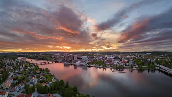 En vacker solnedgång över Umeå med en älv som rinner genom den.
