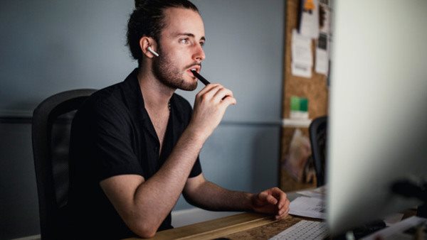 Fundersam och engagerad deltagare vid dator - på kurs i bildbehandling
