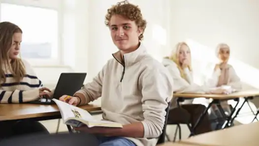 Elever som sitter vid bänkar i klassrummet