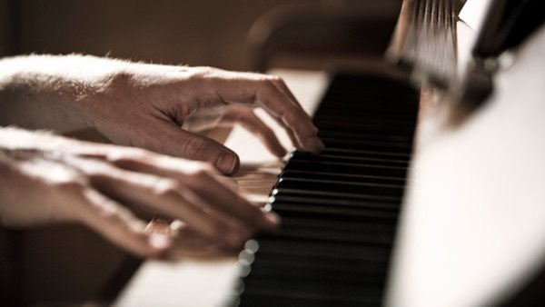 Händer som övar piano på pianokurs