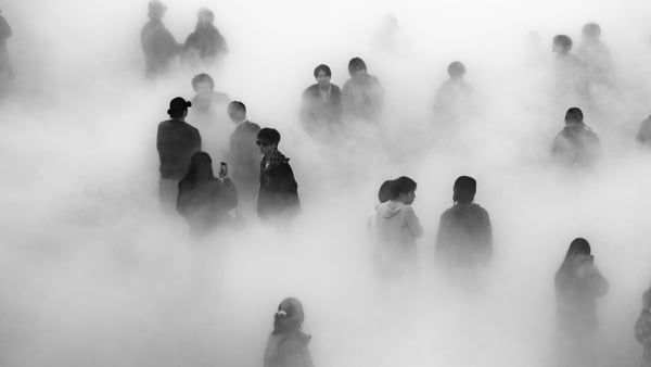 Siluetter av människor i en tät dimma.