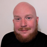 En man med flintskalligt huvud i svart skjorta.