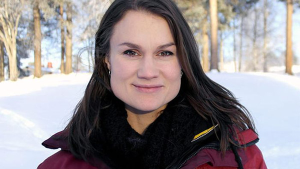 Heidi Andersson står i ett vinterlandskap. Hon har långt, mörk hår, en svart scarfs och en vinröd jacka.
