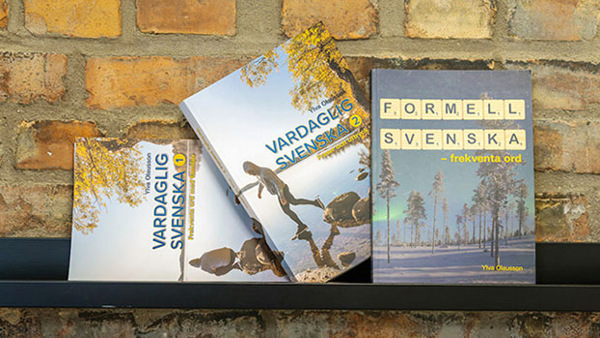 De tre böckerna Vardaglig svenska 1, Vardaglig svenska 2 och Formell svenska på en hylla framför en tegelvägg.
