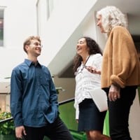 Bild på en man och två kvinnor som konverserar.