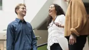 Bild på en man och två kvinnor som konverserar.