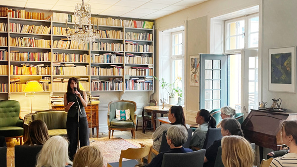 En kvinna som st&aring;r framf&ouml;r en folkmassa.