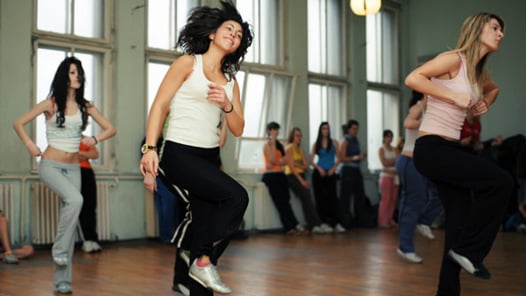 En grupp unga kvinnor dansar i en dansstudio.