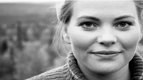 Ett svartvitt foto av en kvinna som ler.