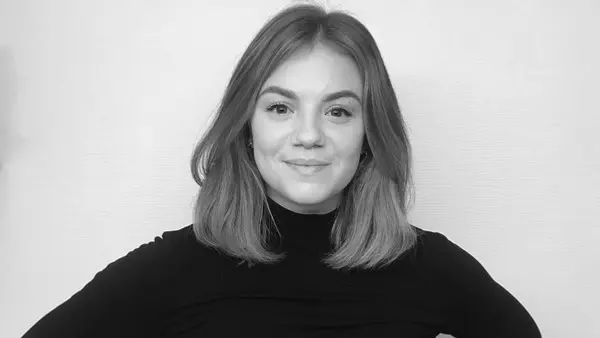 Ett svartvitt foto av en kvinna med h&auml;nderna p&aring; h&ouml;fterna.