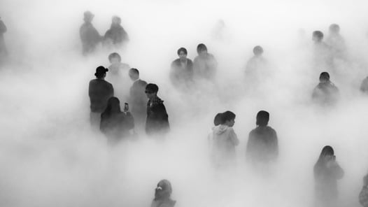 Siluetter av människor i en tät dimma.