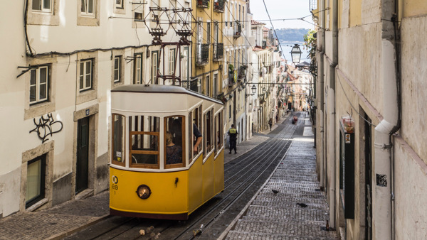 En spårvagn på väg upp för gränd i Portugal dit du kan åka på språkresa för vuxna och lära dig portugisiska