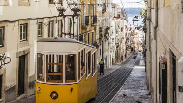 En spårvagn på väg upp för gränd i Portugal dit du kan åka på språkresa för vuxna och lära dig portugisiska