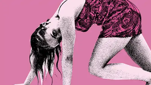 Kvinna i rosa klänning mot rosa bakgrund tittar in i kameran. 