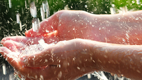 Hands catching clean falling water close up. Environmental concept.