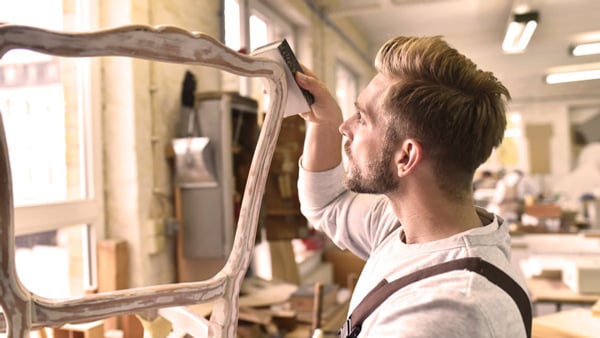 En man arbetar på ett trästycke.