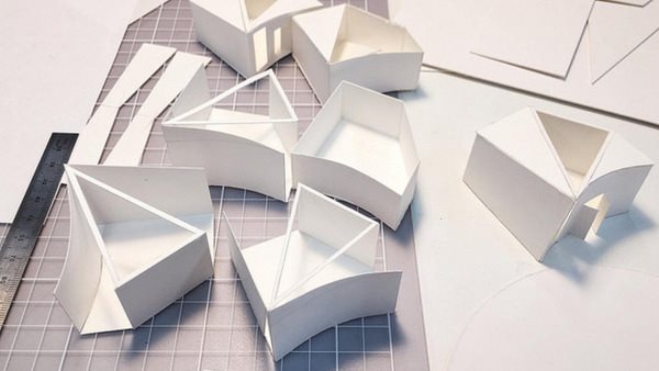 Arkitekturmodeller i papper på arbetsbord 